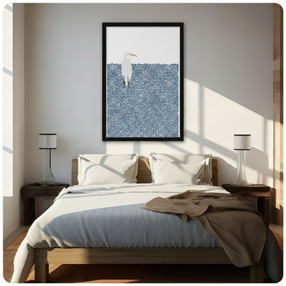 Framed minimalist white great egret standing in a field of navy blue dots wall art hung above a wooden bed with white bedding in a bright sunlit bedroom with twin lamps
