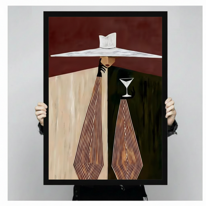 Two hands holding large black framed canvas print of Art Deco elegant woman in oversized white hat holding a crystal martini glass, geometric burgundy and beige composition