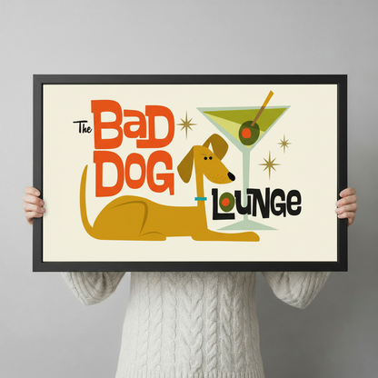 Person in white cable-knit sweater holding The Bad Dog Lounge retro dog bar framed art print showing size reference against grey background