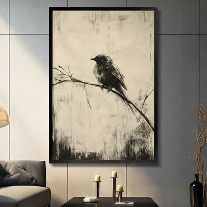Black framed vintage charcoal sketch of a solitary fluffy black bird perched on a bare diagonal branch with a long drooping tail feather above wispy grass strokes on an aged cream parchment background with vertical scratch marks monochrome oil painting canvas wall art displayed in a modern gray living room with dark sofa and metal candlesticks