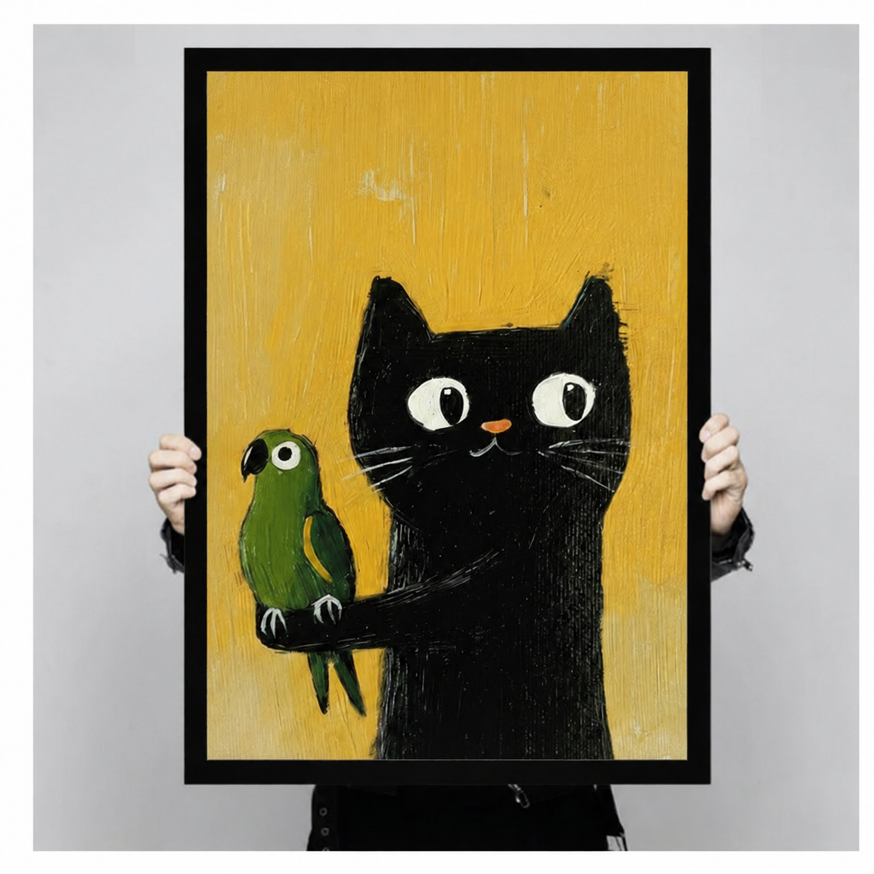 Black framed canvas print featuring a whimsical black cat and green parrot on golden yellow background, hand-held size display