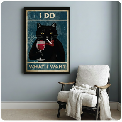 Grumpy black cat vintage art print in black frame on blue-gray wall beside white linen armchair in cozy reading corner