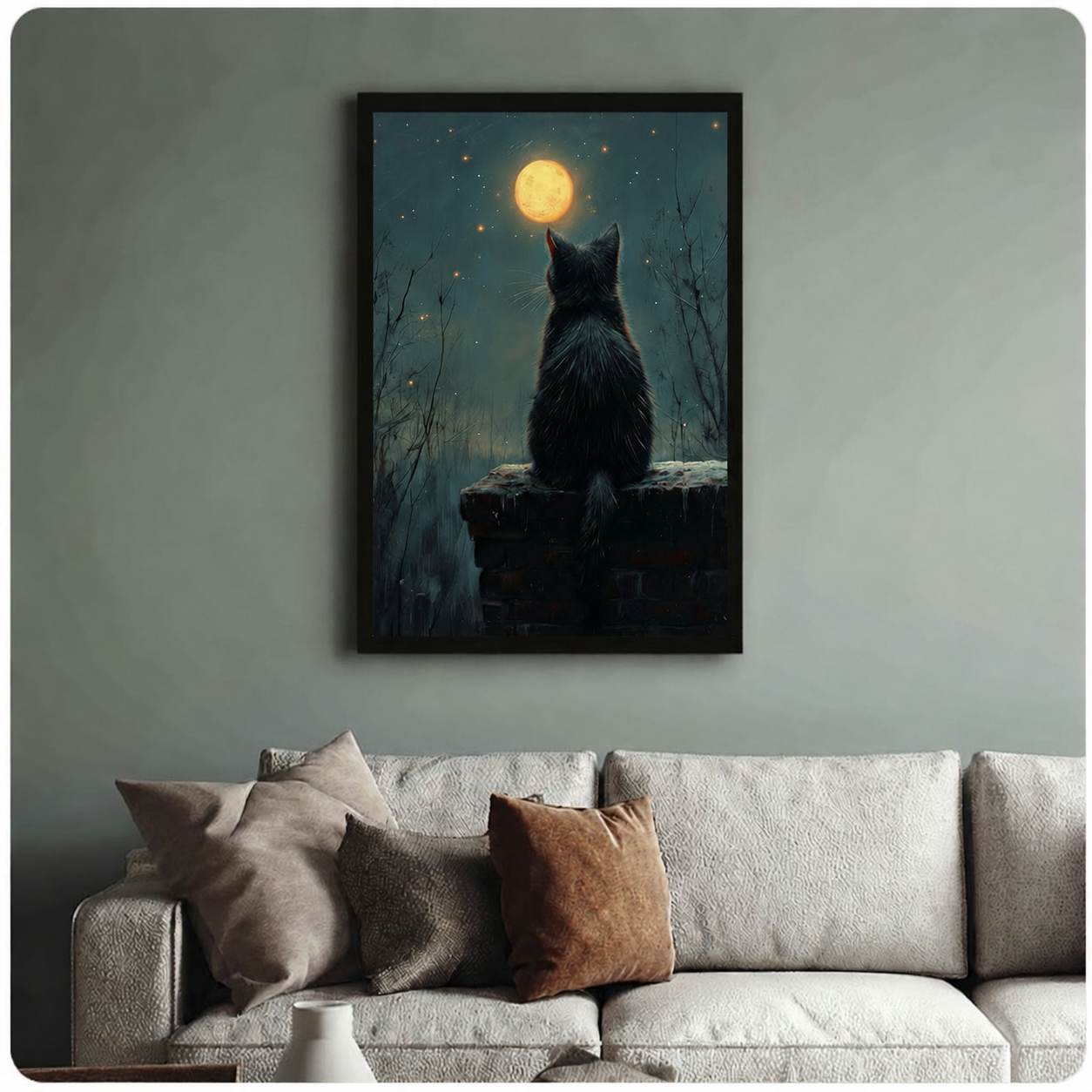 Black framed canvas art of a mysterious cat gazing at the moon at night, hung above a neutral sofa on a sage green wall
