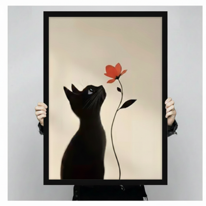 Person holding large framed black cat gazing at red flower canvas print with both hands - close up view of minimalist black cat silhouette and red bloom wall art with cream background and black frame finish