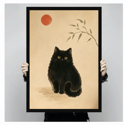 Two hands in black jacket sleeves holding a large black framed Japanese ink painting style illustration of a fluffy round black cat with bright amber eyes sitting upright with a red sun circle upper left and ink bamboo leaves upper right on warm parchment background zen minimalist black cat canvas art print, front-facing vertical product size display