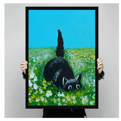 Framed black cat canvas print held by hands — humorous cat butt painting in green meadow with white flowers