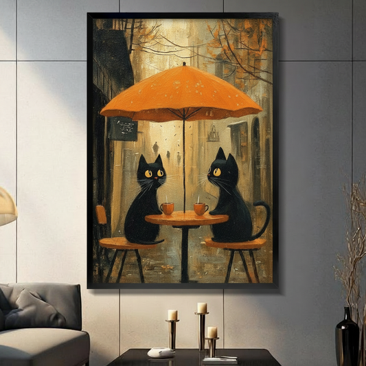 Two black cats enjoying coffee under an orange umbrella at an autumn street café, warm golden foliage backdrop, black framed print in modern living room with dark sofa