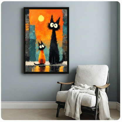 Black cats sunset city canvas wall art in black frame on blue-gray wall beside white cushioned armchair