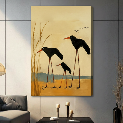 Canvas wrap print featuring a family of three black long-legged shorebirds among golden marsh reeds on warm amber background, hung on grey wall beside dried botanicals