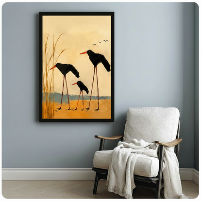 Framed three black long-legged shorebirds in golden marsh wall art displayed beside white linen armchair with throw blanket in minimalist grey reading nook
