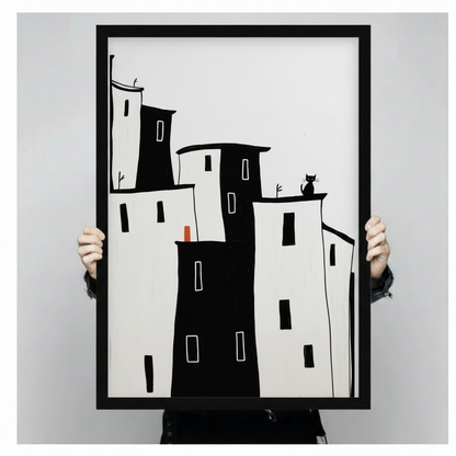 Hand-held black framed poster print of minimalist black and white building silhouettes with black cat on rooftop and small red door detail