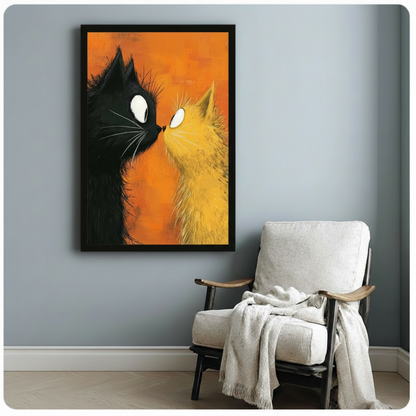 Framed poster of two cats — one black, one golden yellow — gazing at each other with wide eyes on an orange background, displayed beside a linen armchair on a blue-grey wall