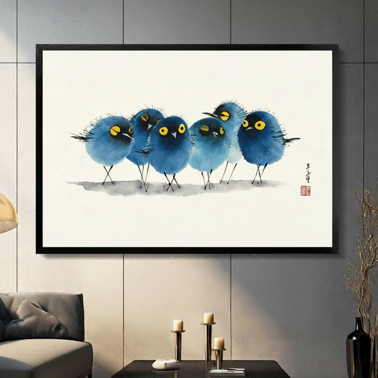 Chinese ink wash painting of four round fluffy blue birds standing in a row each with bright yellow eyes and distinct comic expressions on a clean ivory background with soft ink shadow accents and a red seal stamp funny bird wall art framed print in a living room with dark gray panel wall dark sofa and black vase
