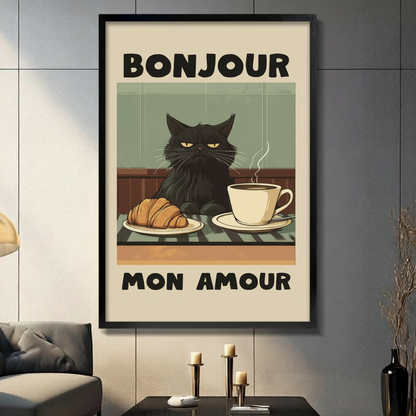 Framed vintage-style poster wall art of a grumpy black cat sitting at a café table with a croissant and steaming coffee cup, with bold "Bonjour Mon Amour" text, displayed in a modern dark grey living room