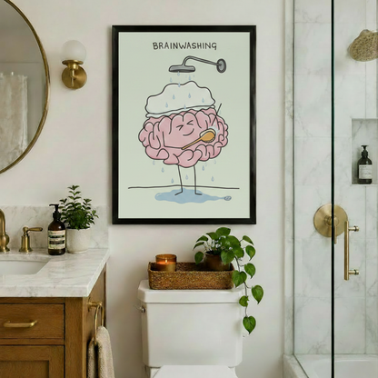 Black framed brainwashing brain art print displayed in an elegant bathroom with gold fixtures, marble countertop, toilet, candle tray and trailing green plant