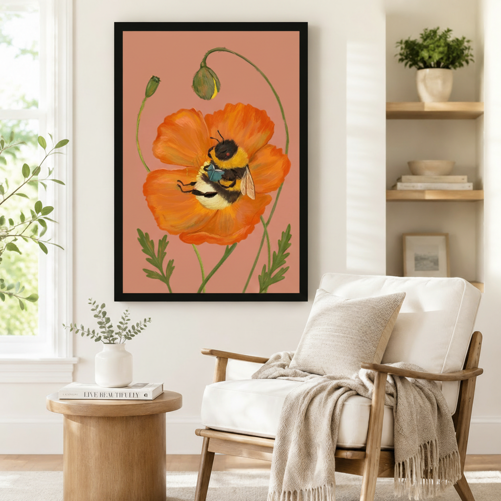 Black-framed botanical art print featuring a bumblebee cradled in an orange California poppy with curling stems and buds, styled beside a linen armchair in a cozy reading corner