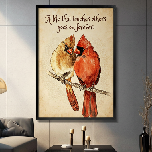 Male and female cardinal birds perched on a branch facing each other with quote a life that touches others goes on forever vintage watercolor bird wall art framed print in a living room with gray tiled wall sofa candle holders and black vase