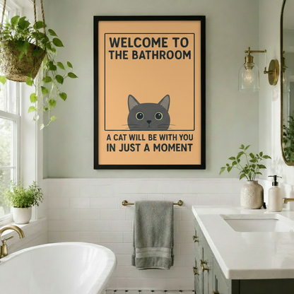 Funny cat bathroom wall art framed print hanging in bright bathroom with freestanding bathtub, plants, and gold hardware