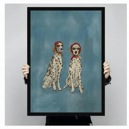 Person in black clothing holding large black framed canvas print of two Dalmatians in red headscarves and sunglasses on dusty blue background