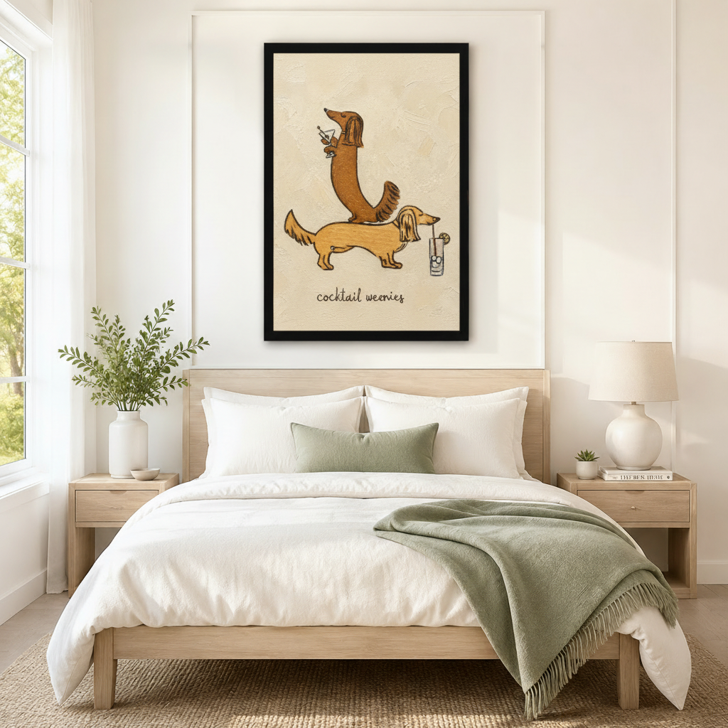 Oversized black-framed canvas of two stacked long-haired dachshunds balancing cocktail drinks with "cocktail weenies" hand-lettered text in warm cream tones, mounted as a playful statement piece above a neutral linen bed in a serene minimalist bedroom