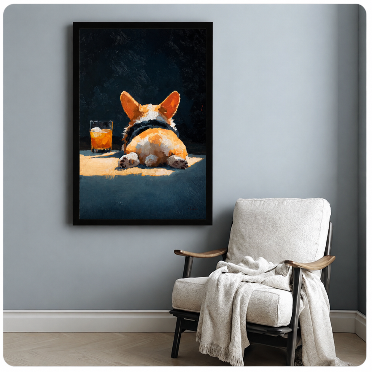 Framed corgi butt oil painting with whiskey glass hung above a white armchair on a light gray wall, humorous dog art for home decor