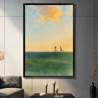 Romantic couple running toward each other on green meadow under golden sunset sky, framed canvas wall art in black frame hung on grey tile wall in modern living room