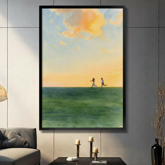 Romantic couple running toward each other on green meadow under golden sunset sky, framed canvas wall art in black frame hung on grey tile wall in modern living room