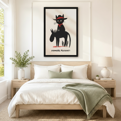 Black framed whimsical cowboy black cat riding a donkey with red hat and red scarf "Onward Peasant" wall art above a light oak bed with white linen bedding, a sage green fringed throw blanket, wooden nightstands, and a white ceramic table lamp in a bright Scandinavian bedroom
