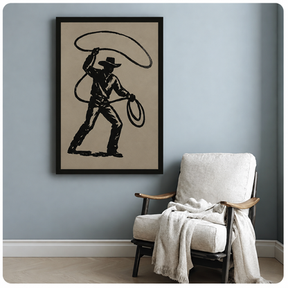 Vintage-style cowboy canvas art in a black frame beside a white armchair against a blue-gray wall.