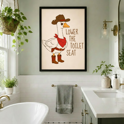 Funny cartoon illustration of a grumpy white goose in a brown cowboy hat red bandana and cowboy boots with the text Lower The Toilet Seat on a cream background funny bathroom wall art framed print in white tile bathroom with freestanding bathtub gold fixtures and trailing plants
