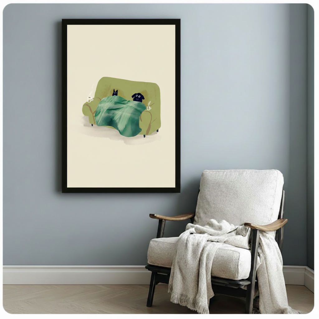 Black framed lazy cat and dog under a blanket canvas art showing a black cat and black dog lounging on a green couch sharing a teal throw with steaming mugs on either side against a soft cream background, displayed on a blue-gray wall beside a light upholstered wooden armchair draped with a cream knit throw blanket