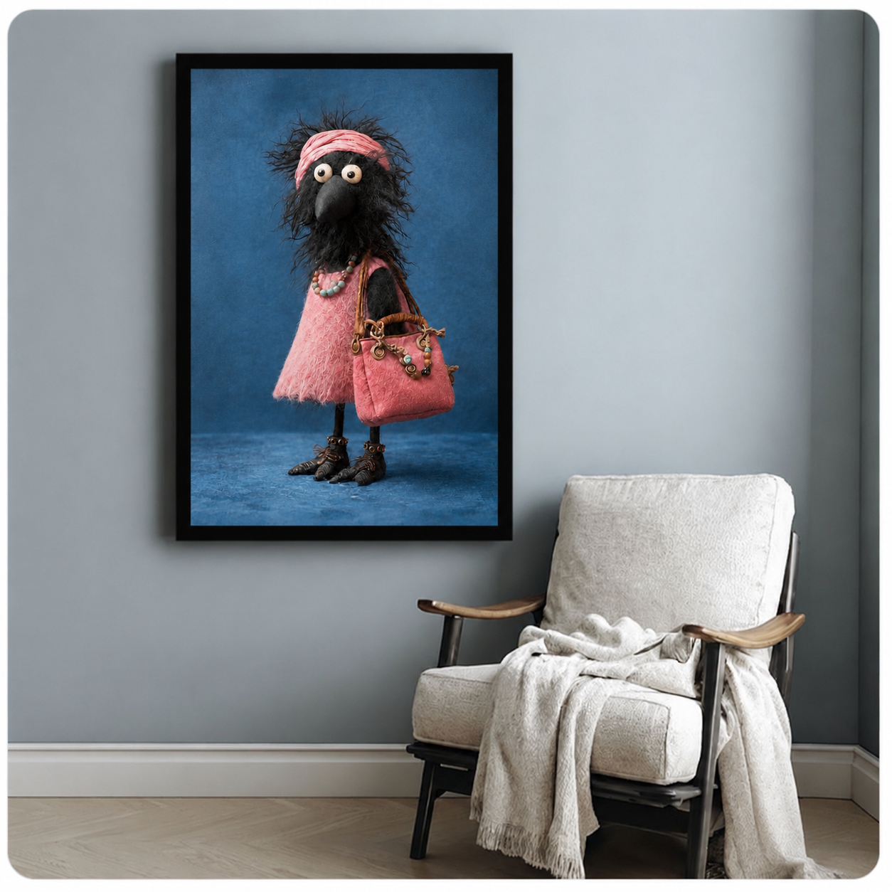 Black framed poster of a funny crow in a pink textured dress and ankle boots with a pink bag, styled next to a linen armchair in a cozy room