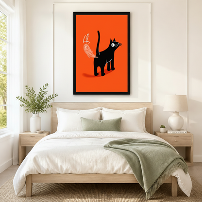 Black framed playful cartoon black cat holding a bird toy canvas art featuring a wide-eyed black cat with a raised tail swinging a plump pink-orange bird on a string beside the hand-lettered Twoo on a vivid orange-red background, displayed above a light wooden bed with white linen bedding, a sage green throw pillow, matching round nightstand lamps, and a white vase of greenery in a bright minimalist bedroom