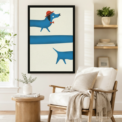 Large black-framed wall art of a stylish blue dachshund with a red hat and bow tie in clean geometric illustration style, styled beside a linen armchair and round side table in a Scandinavian reading corner