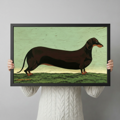 Person in white cable knit sweater holding a large black framed vintage folk art dachshund portrait print with green background in a neutral studio setting