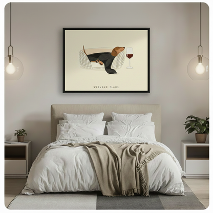 Black framed dachshund wall art hung above a bed in a minimalist bedroom with white bedding, pendant lights and neutral tones