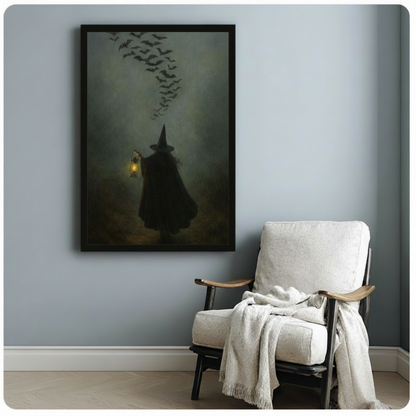 Framed dark fantasy witch wall art print with a glowing lantern and swirling bats, hung beside a cozy white armchair on a soft blue wall