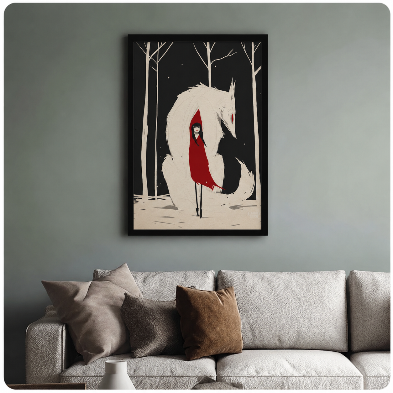 Framed fantasy art print of a red-hooded figure nestled against a white wolf in a dark snowy forest, styled above a neutral linen sofa on a sage green wall