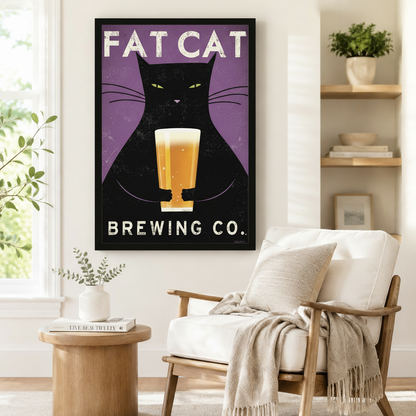 Black framed Fat Cat Brewing Co retro beer cat poster art print on purple background beside wooden accent chair and round side table in bright Scandinavian reading nook
