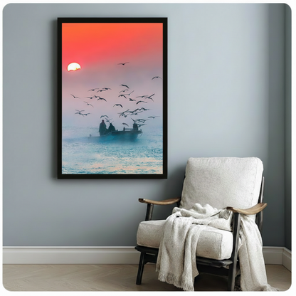 Framed fishermen boat sunrise seagulls ocean wall art beside wooden accent chair with linen throw - moody coastal landscape canvas print with silhouette figures and dramatic dawn sky