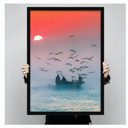 Hands holding large framed fishermen boat at sunrise canvas print - full artwork detail of seagull flock silhouette figures on misty ocean with vivid coral red gradient sunrise sky