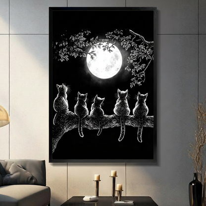 Five cats sitting side by side on a tree branch gazing at a glowing full moon surrounded by detailed white leaf illustrations on a pure black background gothic cat wall art framed print in a living room with light gray tiled wall dark sofa candle holders and black vase