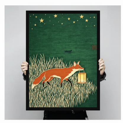 Close-up of framed fox and lantern wall art print held by hands, showing detailed woodblock-style illustration