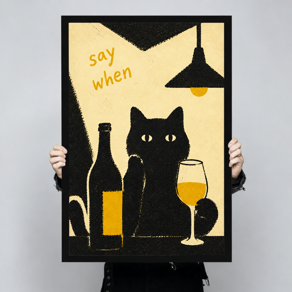 Framed black cat wine canvas wall art held by hands, featuring a black cat, wine bottle, and “say when” lettering