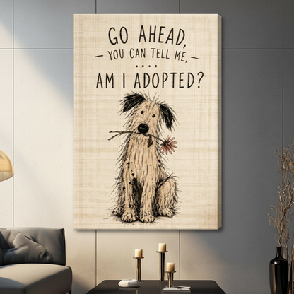 Stretched canvas wall art featuring a scruffy black and white shaggy dog sitting with a daisy stem in its mouth beneath the humorous go ahead you can tell me am I adopted quote in bold hand-lettered typography on a distressed linen beige background, hung on a dark gray tile wall beside a modern charcoal sofa