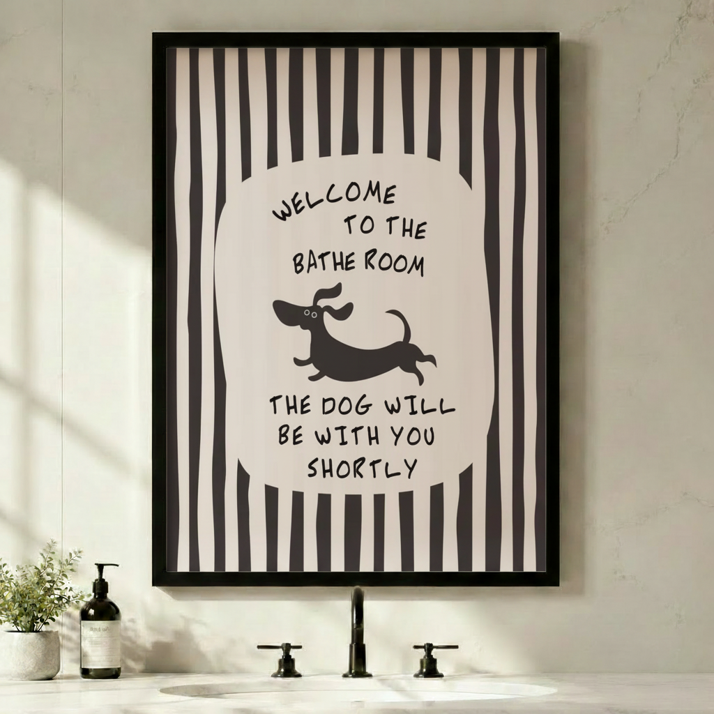 Black framed funny bathroom dachshund stripe canvas art with bold black and white vertical stripes and a central oval featuring hand-lettered welcome to the bathroom above a running cartoon dachshund silhouette and the quote the dog will be with you shortly in a minimalist black and white bathroom above a sink with a black faucet and soap dispenser