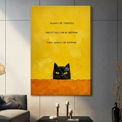 Stretched canvas wall art featuring a sneaky black cat with glowing yellow eyes peeking over a rough orange surface beneath a humorous batman quote on a bright yellow background, hung on a dark gray wall with candlestick decor beside a modern gray sofa
