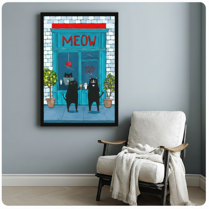 Black framed funny black cat Meow Cafe canvas art print with two upright cats holding coffee drinks outside a teal storefront with red MEOW sign and green potted plants on a blue-grey wall beside a white linen armchair with draped throw