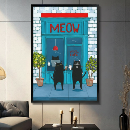 Framed funny illustration canvas wall art of two black cats standing upright outside a teal blue Meow Cafe storefront holding coffee cups with red signage and potted green plants on a dark grey wall in a modern living room with candle holders