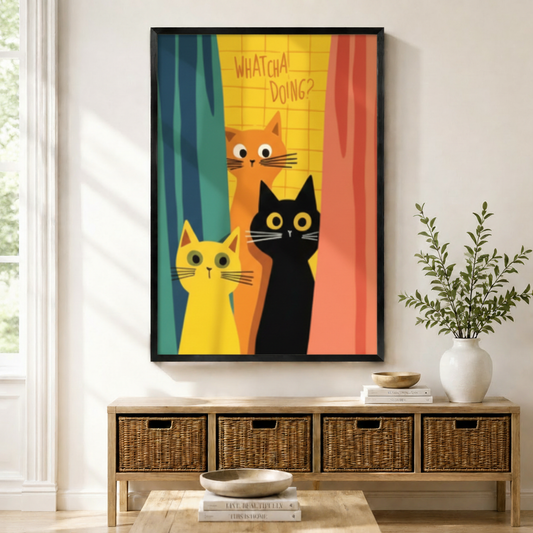 Black framed funny cats Whatcha Doing canvas art with three wide-eyed cartoon cats — orange, yellow, and black — peeking through colorful teal yellow and coral curtains on a bold retro background, displayed above a rattan storage console in a bright entryway